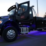 Black tow truck with blue lights